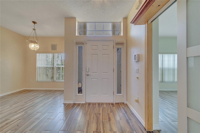 entryway with a high ceiling and a notable chandelier