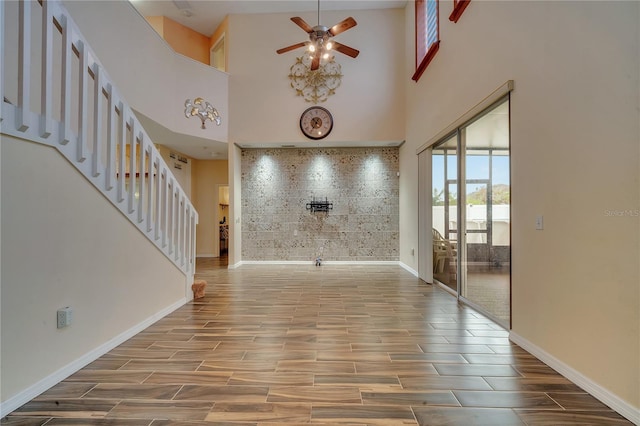 entryway featuring ceiling fan and a towering ceiling