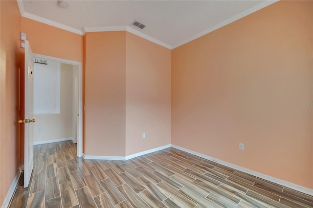 empty room with a textured ceiling and crown molding