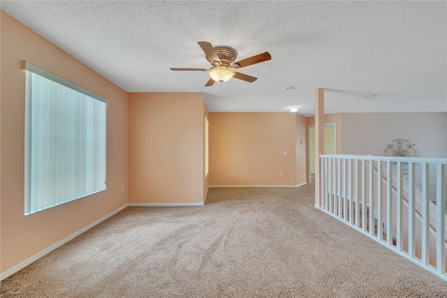 carpeted spare room with ceiling fan and a textured ceiling