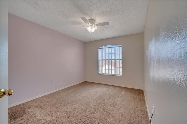 carpeted empty room featuring ceiling fan and a textured ceiling