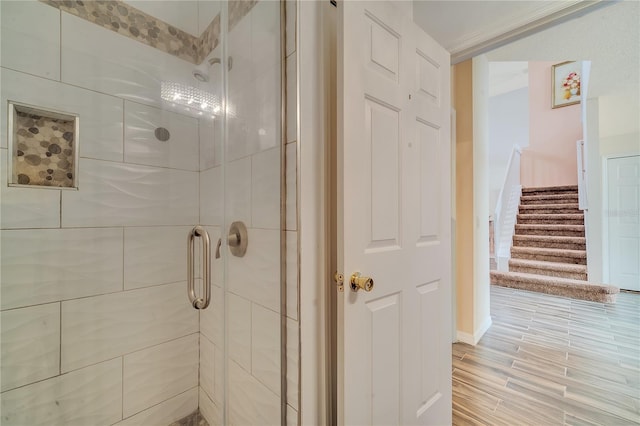 bathroom with hardwood / wood-style flooring and walk in shower