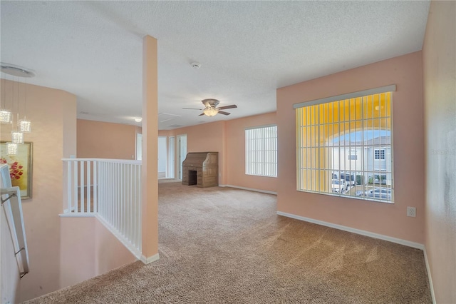 spare room featuring carpet flooring, a textured ceiling, and ceiling fan