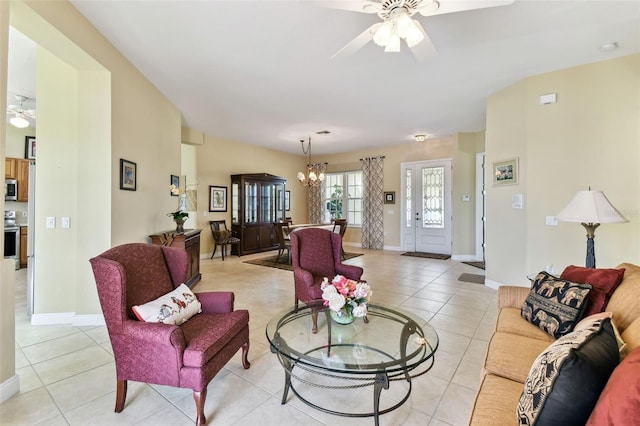 living room featuring light tile patterned floors and ceiling fan with notable chandelier