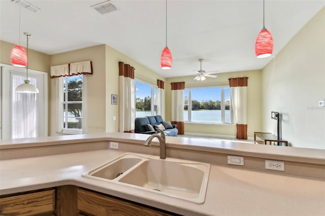 kitchen featuring pendant lighting, plenty of natural light, ceiling fan, and sink