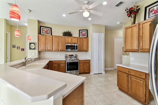 kitchen with sink, hanging light fixtures, light tile patterned floors, kitchen peninsula, and stainless steel appliances