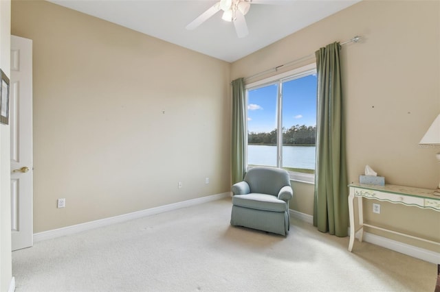 living area featuring carpet flooring, ceiling fan, and a water view