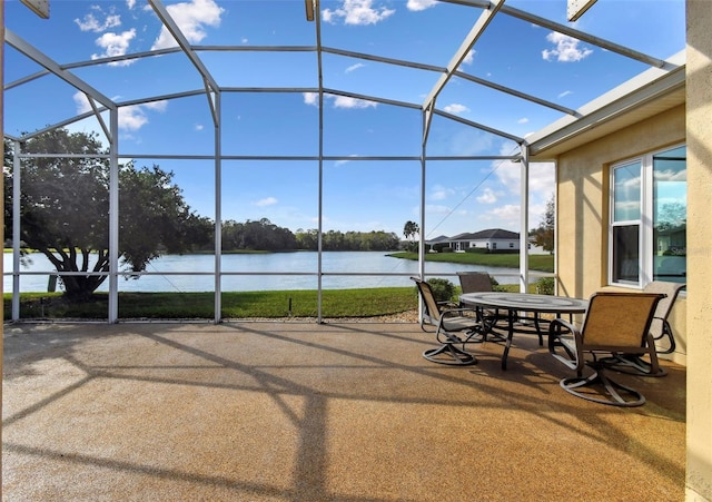 view of patio featuring glass enclosure and a water view