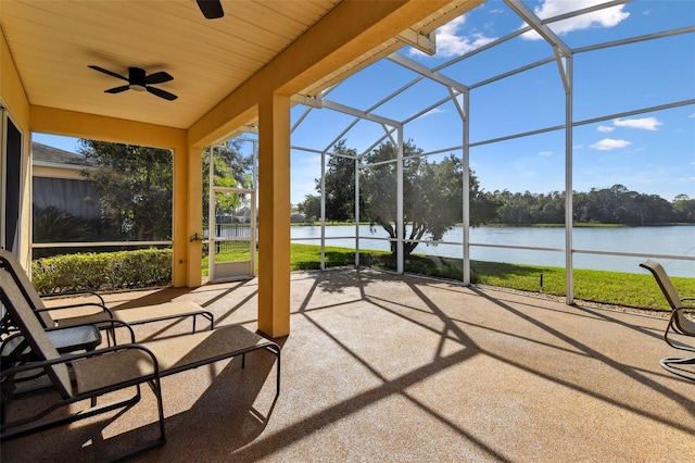 unfurnished sunroom with ceiling fan and a water view