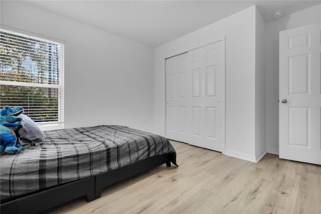 bedroom with light wood-type flooring and a closet