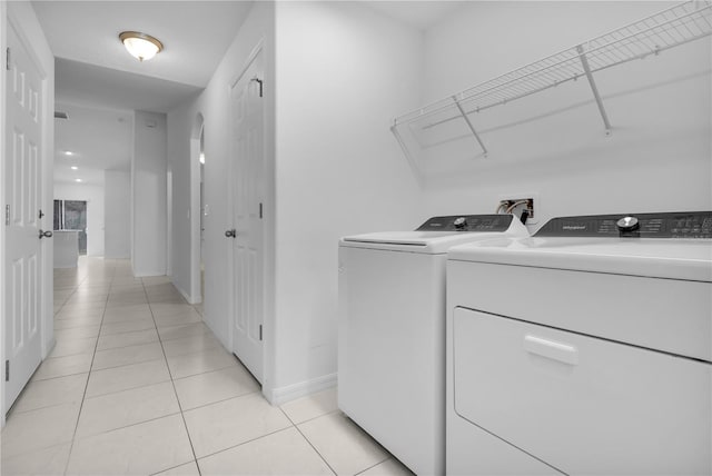 laundry area with light tile patterned floors and washer and clothes dryer