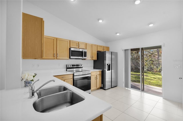 kitchen featuring light brown cabinets, lofted ceiling, sink, light tile patterned floors, and appliances with stainless steel finishes