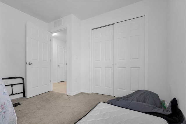 bedroom with light carpet and a closet