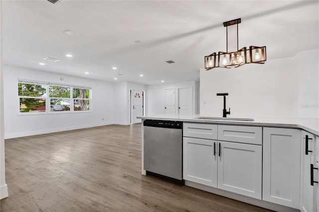 kitchen featuring light wood-type flooring, stainless steel dishwasher, sink, pendant lighting, and white cabinets