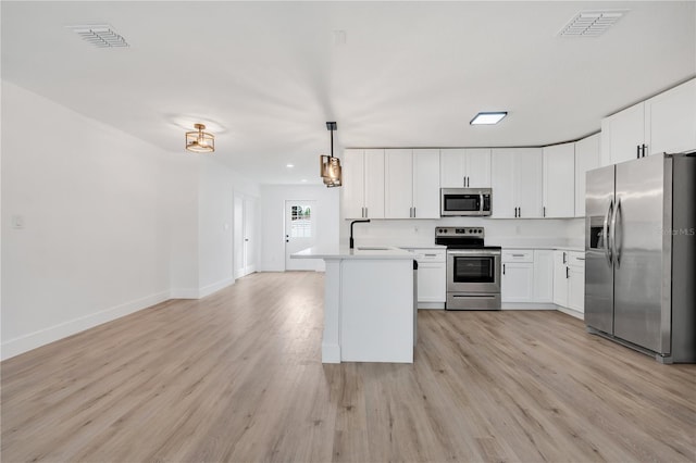 kitchen featuring pendant lighting, white cabinets, sink, and appliances with stainless steel finishes