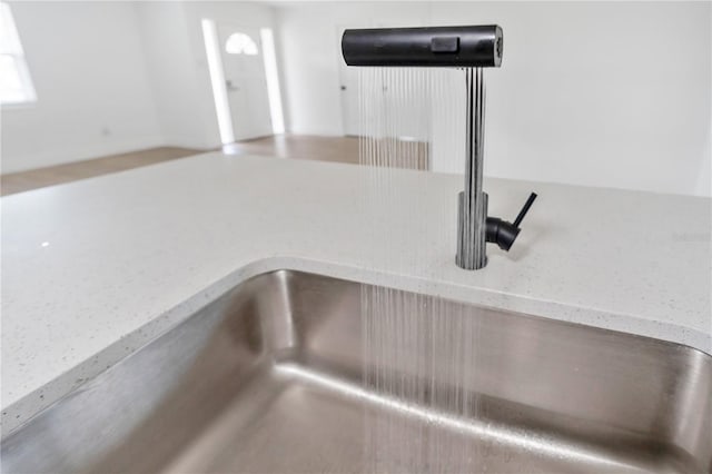 interior details featuring light stone counters and sink