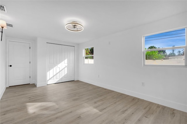 unfurnished bedroom with a closet and light hardwood / wood-style floors