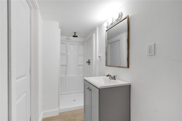 bathroom with vanity, hardwood / wood-style flooring, and walk in shower