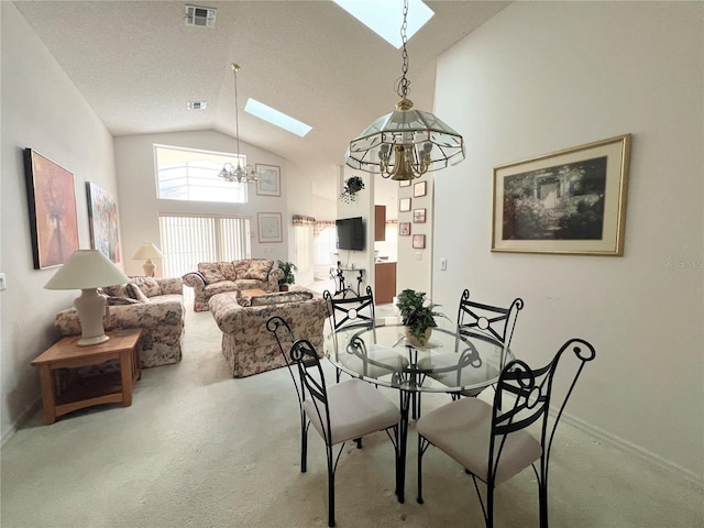 carpeted dining area with lofted ceiling with skylight and an inviting chandelier