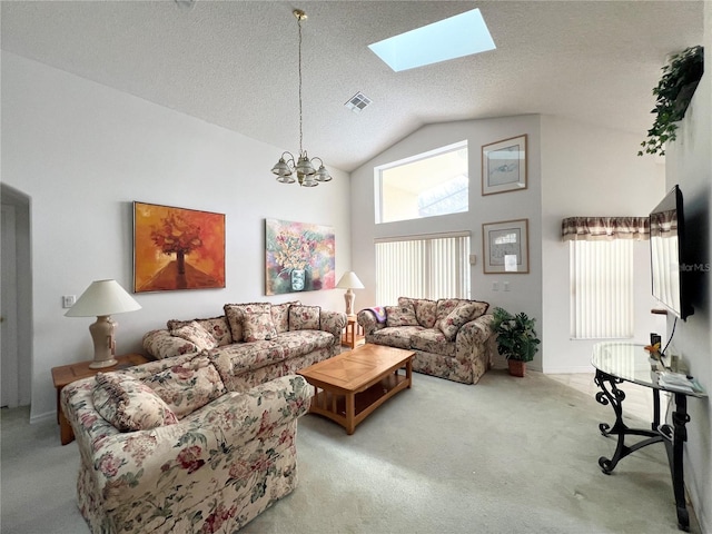 living room featuring light carpet, vaulted ceiling with skylight, a textured ceiling, plenty of natural light, and a chandelier