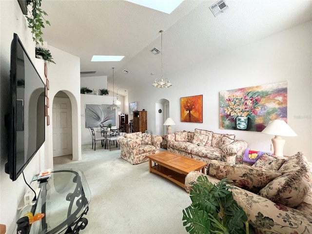 living room featuring carpet, a skylight, a textured ceiling, high vaulted ceiling, and a notable chandelier