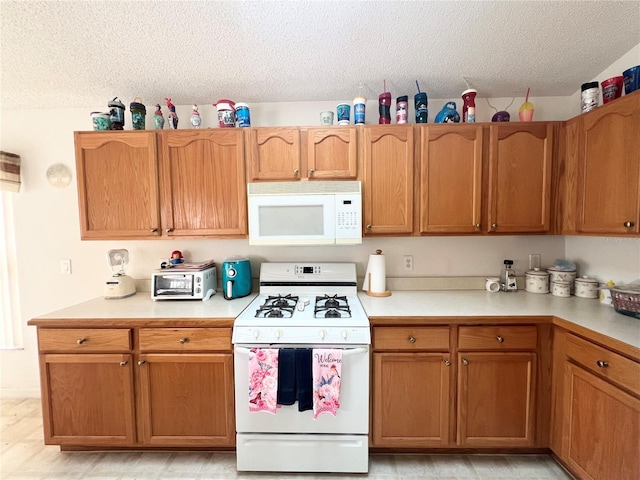 kitchen featuring white appliances and a textured ceiling