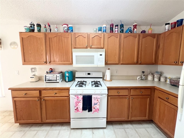 kitchen with white appliances and a textured ceiling