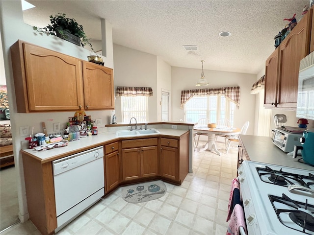 kitchen with sink, hanging light fixtures, kitchen peninsula, lofted ceiling, and white appliances