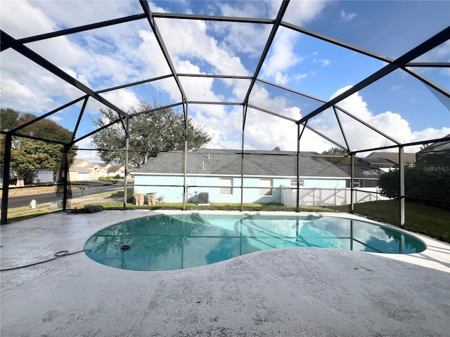 view of swimming pool featuring glass enclosure and a patio area