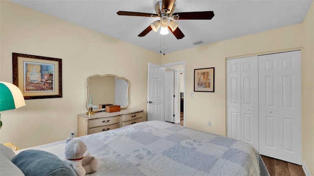 bedroom featuring ceiling fan, dark wood-type flooring, and a closet