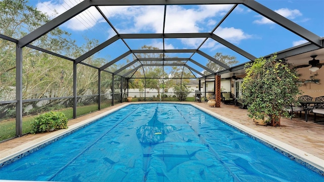 view of swimming pool featuring a patio, glass enclosure, ceiling fan, and a grill