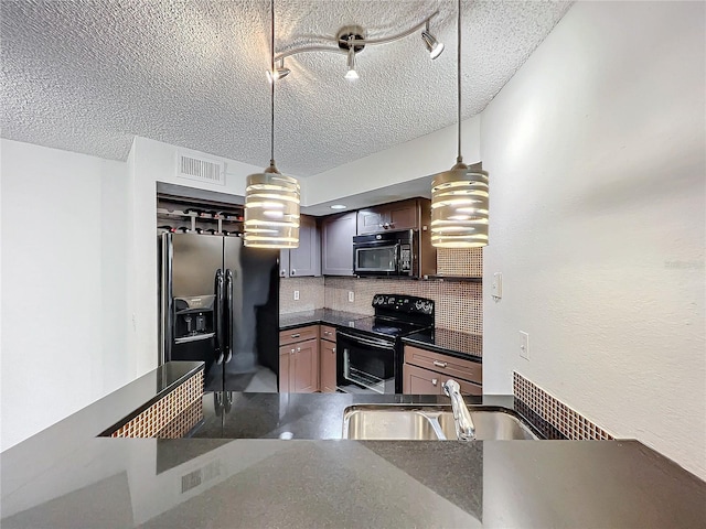 kitchen with range with electric stovetop, stainless steel fridge, sink, and pendant lighting