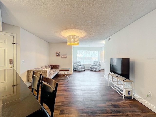 living room with dark hardwood / wood-style flooring and a textured ceiling