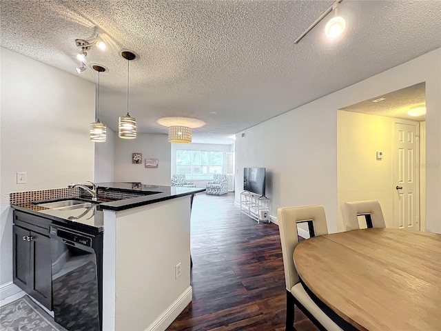 kitchen with a textured ceiling, kitchen peninsula, dishwasher, and decorative light fixtures