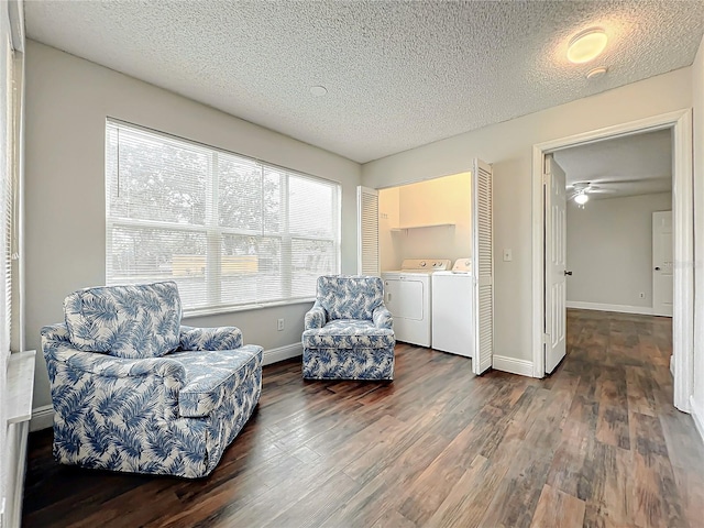 living area with washing machine and dryer, ceiling fan, dark hardwood / wood-style flooring, and a textured ceiling