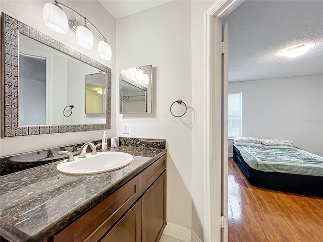 bathroom with hardwood / wood-style flooring, vanity, and a textured ceiling