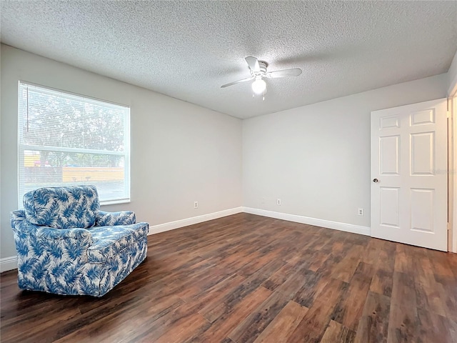 living area featuring a textured ceiling, dark hardwood / wood-style floors, and ceiling fan