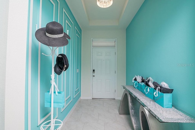 interior space featuring a tray ceiling and light tile patterned flooring