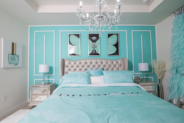 carpeted bedroom with a tray ceiling and an inviting chandelier