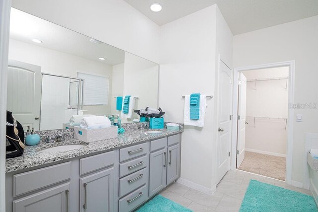 bathroom featuring tile patterned floors, vanity, and a shower with shower door