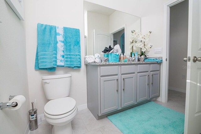 bathroom featuring tile patterned flooring, vanity, and toilet