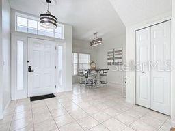 tiled entrance foyer featuring an inviting chandelier