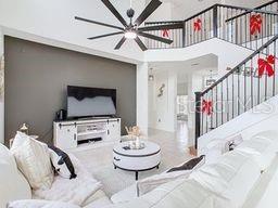 living room featuring ceiling fan and a towering ceiling