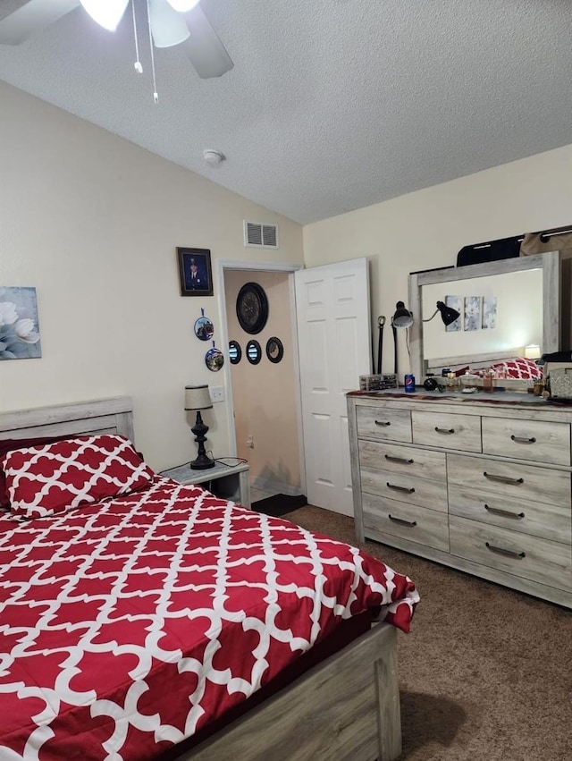 carpeted bedroom featuring vaulted ceiling, ceiling fan, and a textured ceiling