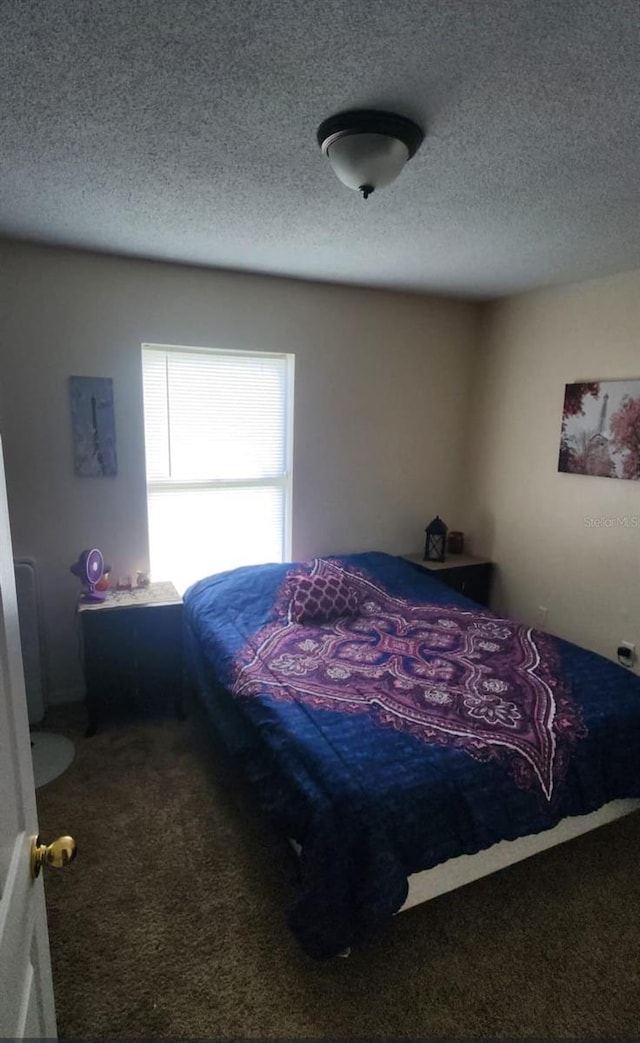 carpeted bedroom featuring a textured ceiling