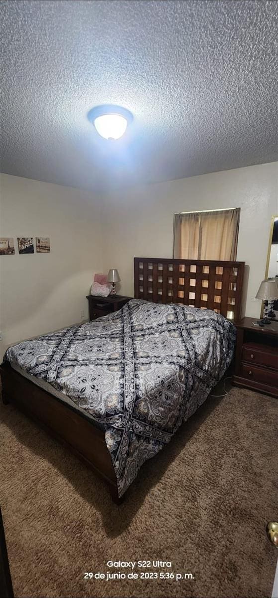 carpeted bedroom featuring a textured ceiling