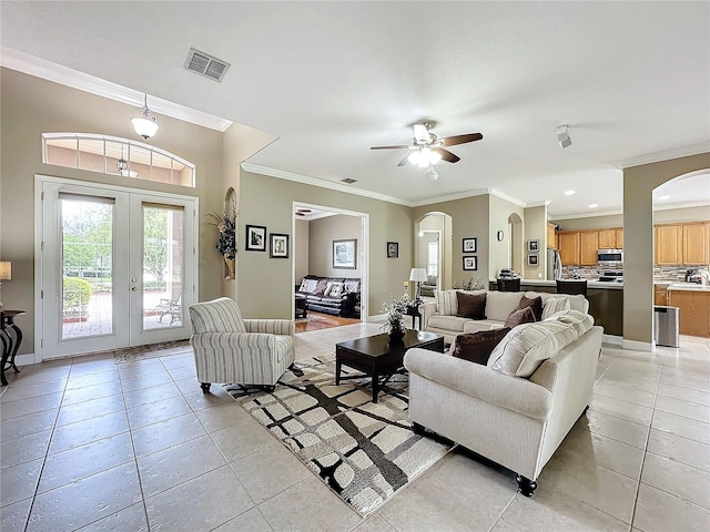 tiled living room with french doors, ceiling fan, and crown molding