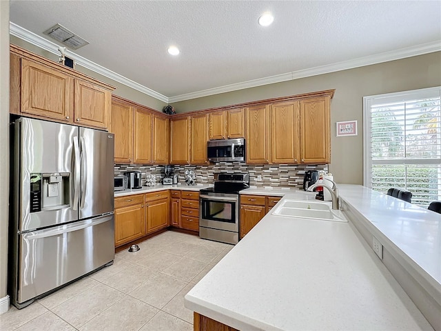 kitchen featuring crown molding, sink, decorative backsplash, light tile patterned floors, and appliances with stainless steel finishes