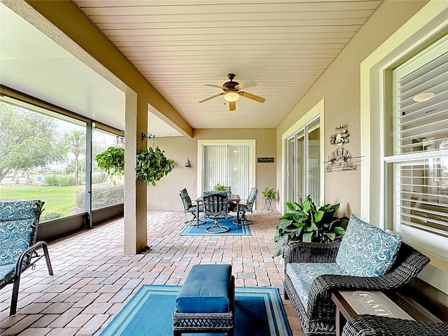 sunroom / solarium featuring ceiling fan