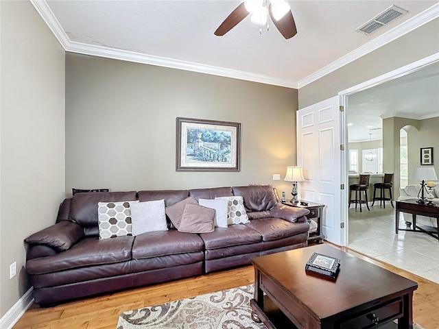 living room with hardwood / wood-style floors, ceiling fan, and crown molding